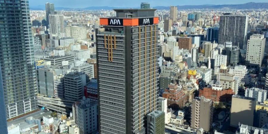 A panoramic view from the top of a tall building, showcasing the city skyline and surrounding landscape.